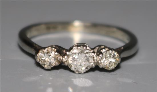 A 1930s 18ct white gold and three stone diamond ring, size P.